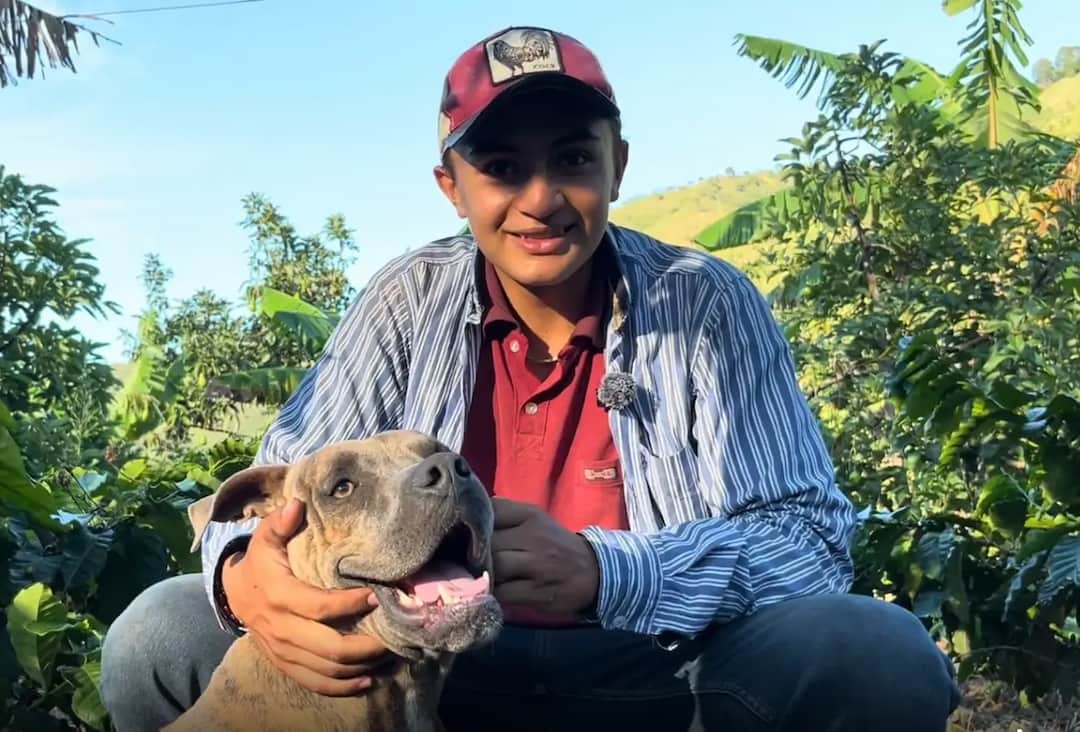 The red mountain Coffee farmer holding a dog outdoors